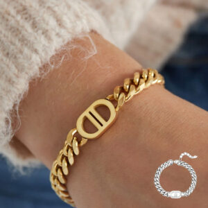 Goudkleurige schakelarmband met DD-detail gedragen om de pols – minimal chic statement armband